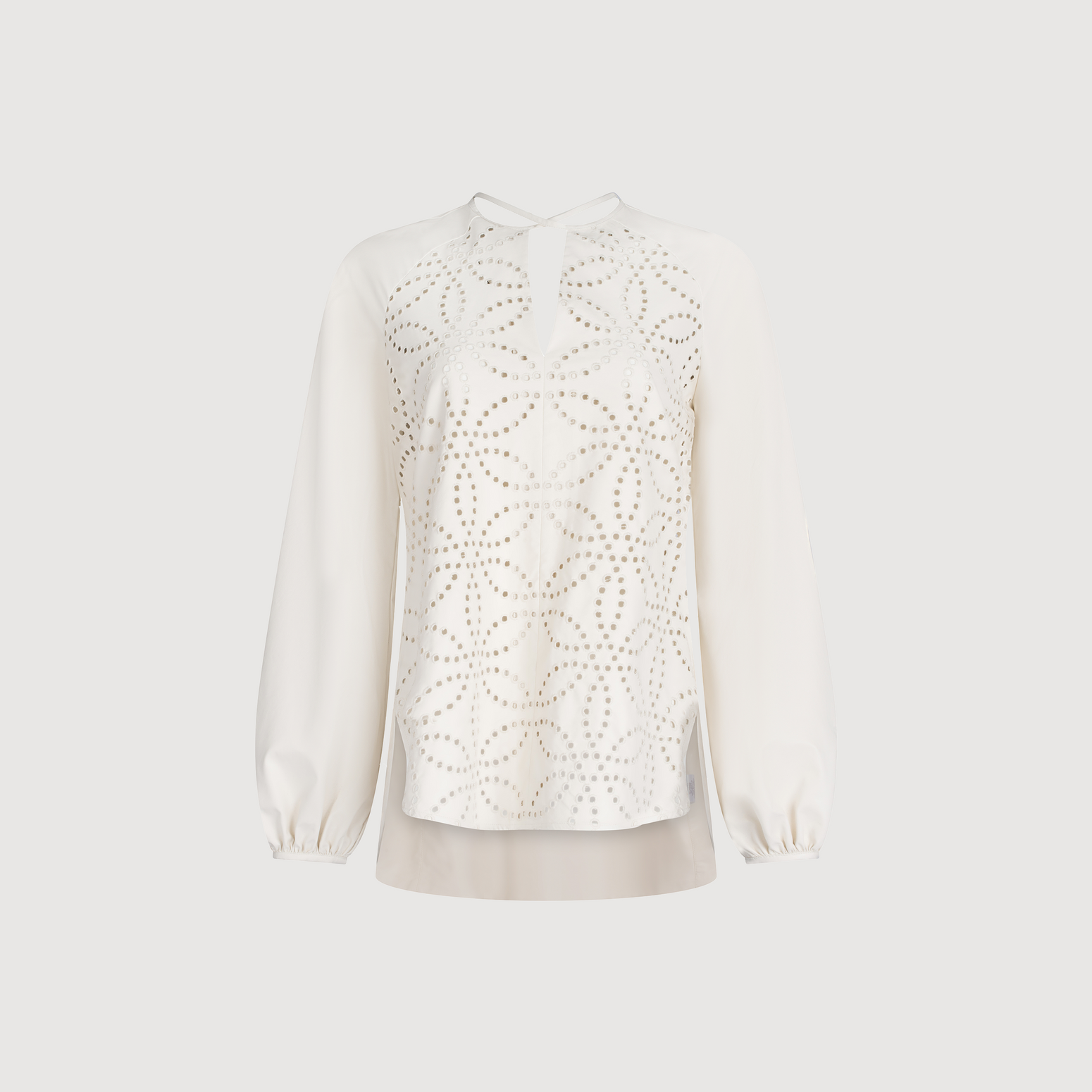 The Molveno Blouse Pearl is a white long-sleeve ecoleather blouse, featuring a geometric pattern on the front, a keyhole neckline, and a rounded hem.