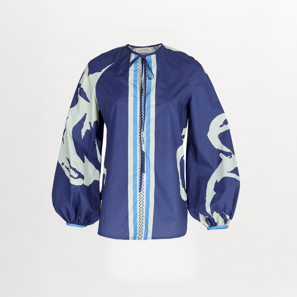 A blue Molveno Blouse Navy Stripes Bloom with a printed white and blue pattern.