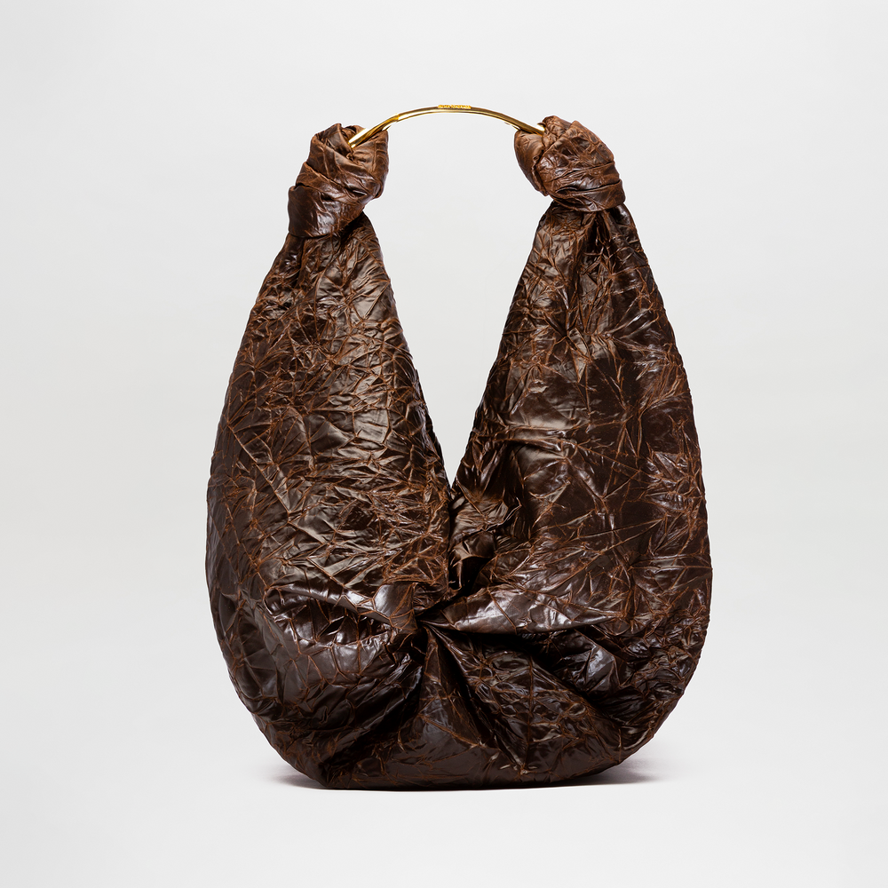 The Sofia Bag (Maxi) is a large, dark brown crinkled bag featuring a knot design and a rounded gold-toned handle, displayed against a plain light background.