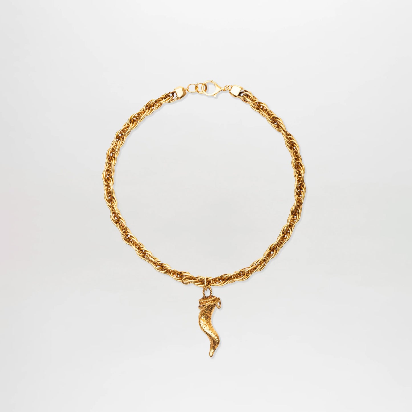 The Narumi Necklace is a gold-plated brass chain with a twisted rope design and horn-shaped pendant, shown on a plain white background. This chunky accessory adds bold elegance to any outfit.