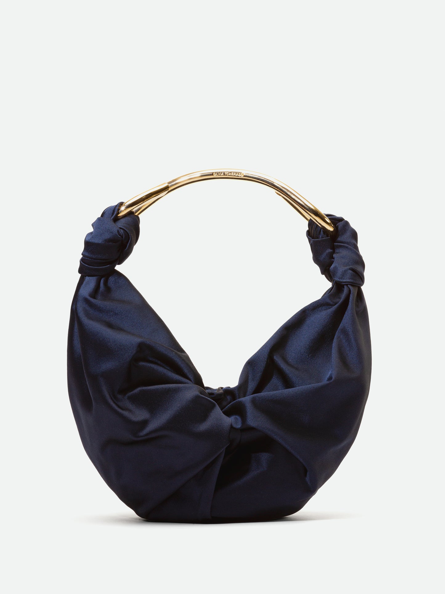 A Sofia Bag (Small) Navy with twisted details and a gold circular handle, available for pre-order now and will ship by November 2024, isolated on a white background.