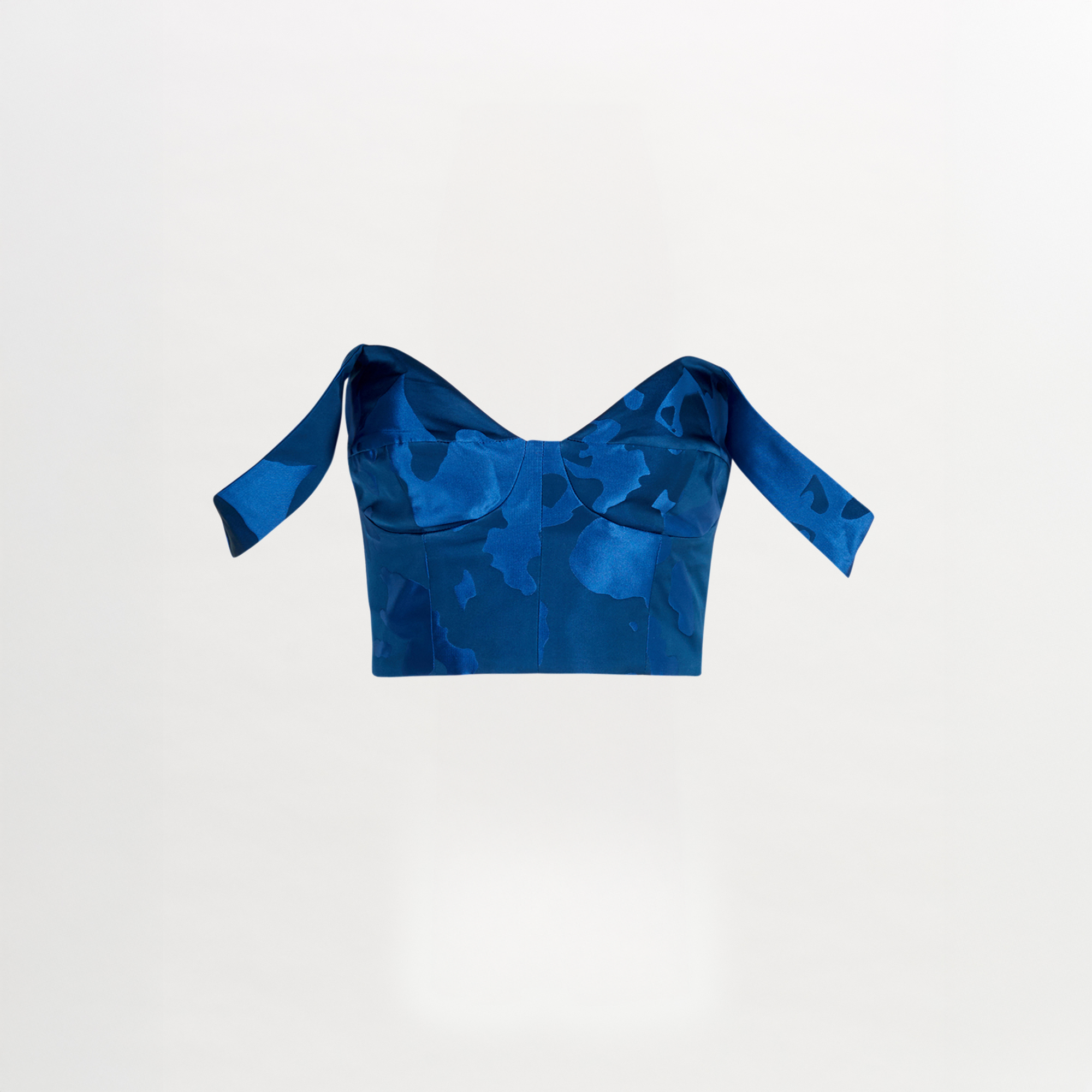 Blue camouflage-patterned crop top on a light gray background