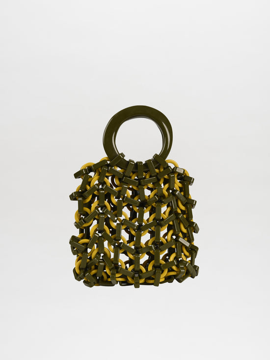 The Omegna Handbag in Green and Yellow, featuring circular acrylic handles, sits stylishly on a plain background.