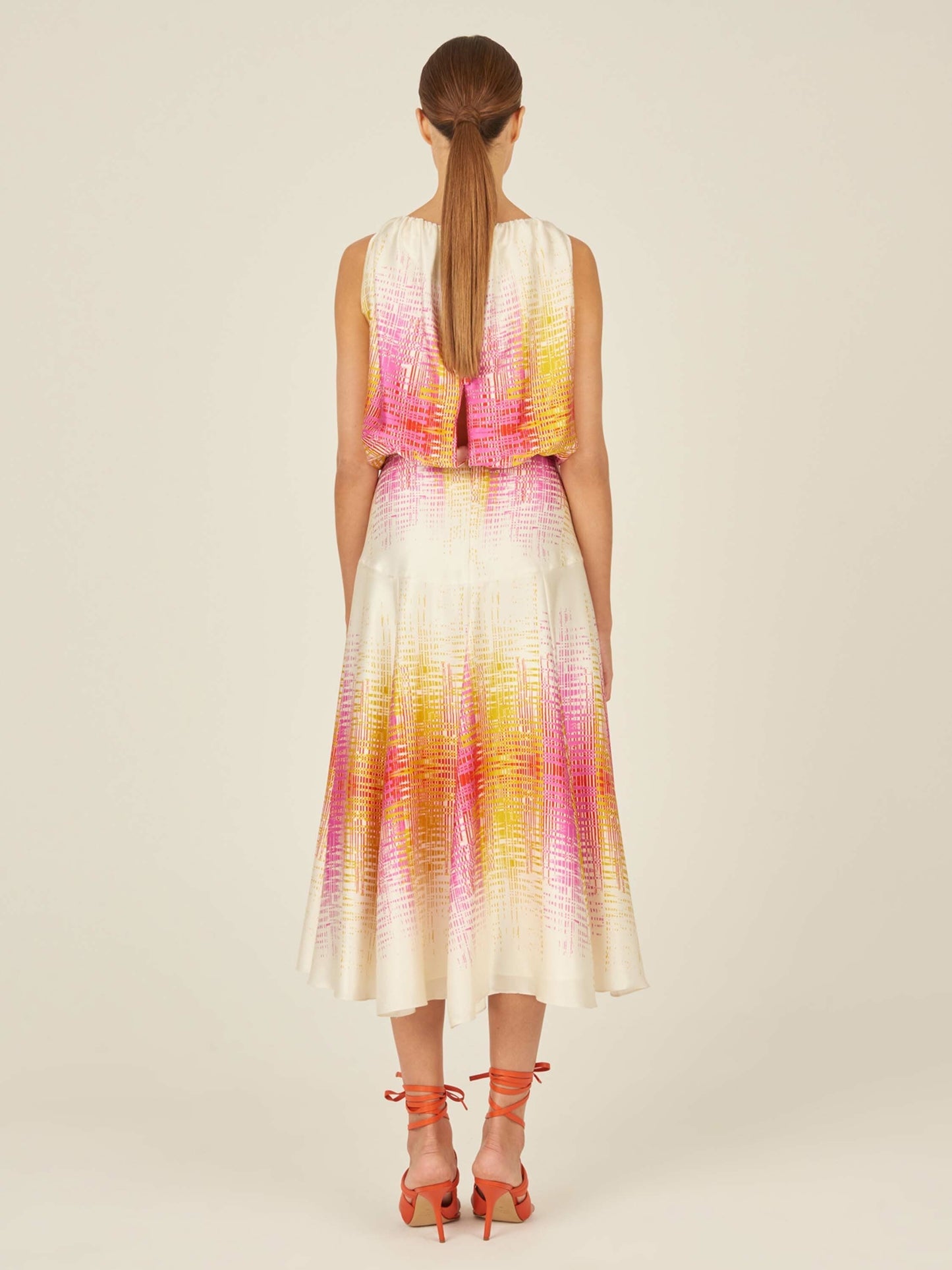 Introducing the Daila Dress White Digital from our Pre Fall 2023 collection, a stunning sleeveless piece featuring a vibrant digital electric print with a gradient of pink, orange, and white. This dress pairs a chic blouson top with a long flowing skirt.