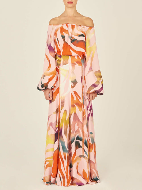 A person wearing a long-sleeve Iona Skirt Blush Prismatic dress, featuring a colorful abstract zebra print in crepe de viscose, stands against a plain background.