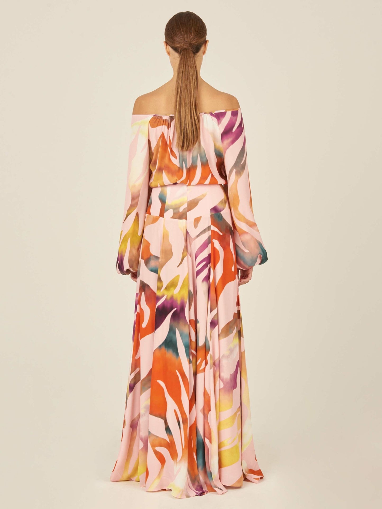 The Iona Skirt Blush Prismatic is a long wrap skirt made from soft viscose fabric, showcasing a multicolored abstract pattern against a plain white background.