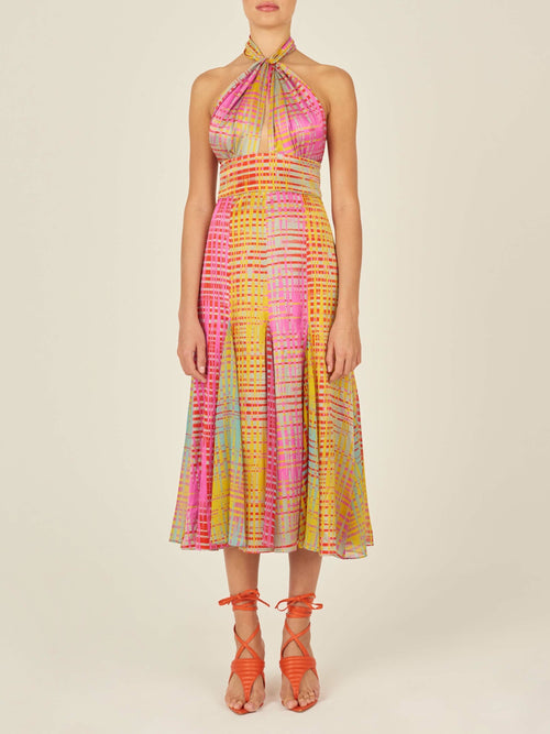 The Silvana Dress White Digital boasts a vibrant twist-halter silhouette with a stunning geometric pattern in pink, yellow, and blue tones on digitally electric printed chiffon.