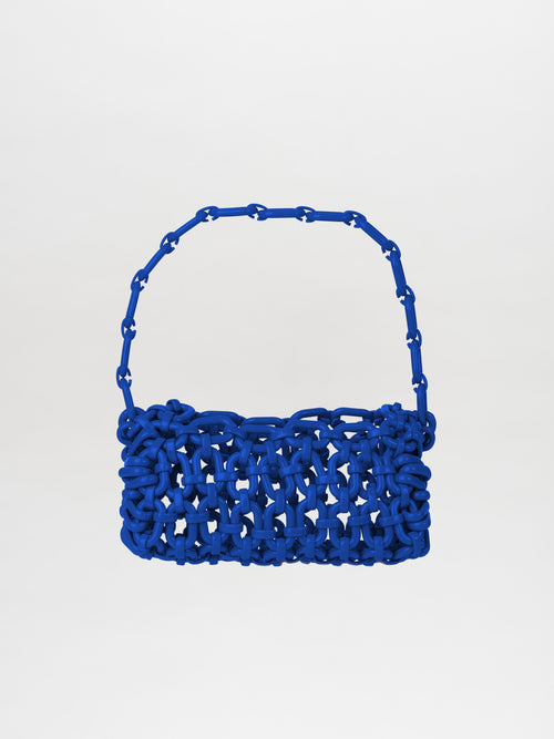 The Piceno Handbag Blue showcases a loop handle crafted from woven material in a rich royal blue shade, set against a plain white backdrop.