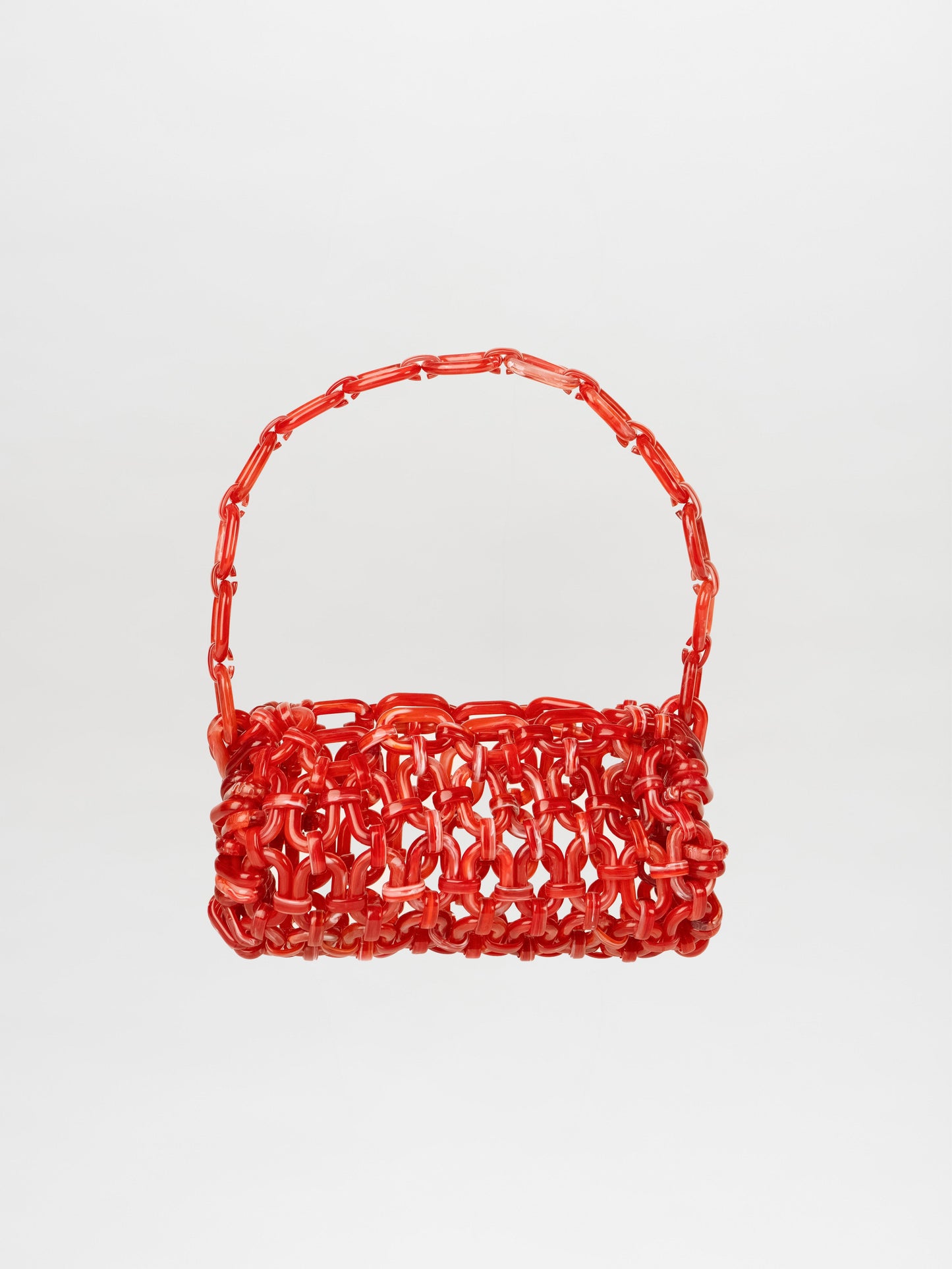 A red Piceno Handbag, featuring a woven design and a matching handle, shaped like a baguette-like rectangle, is displayed against a plain white background.