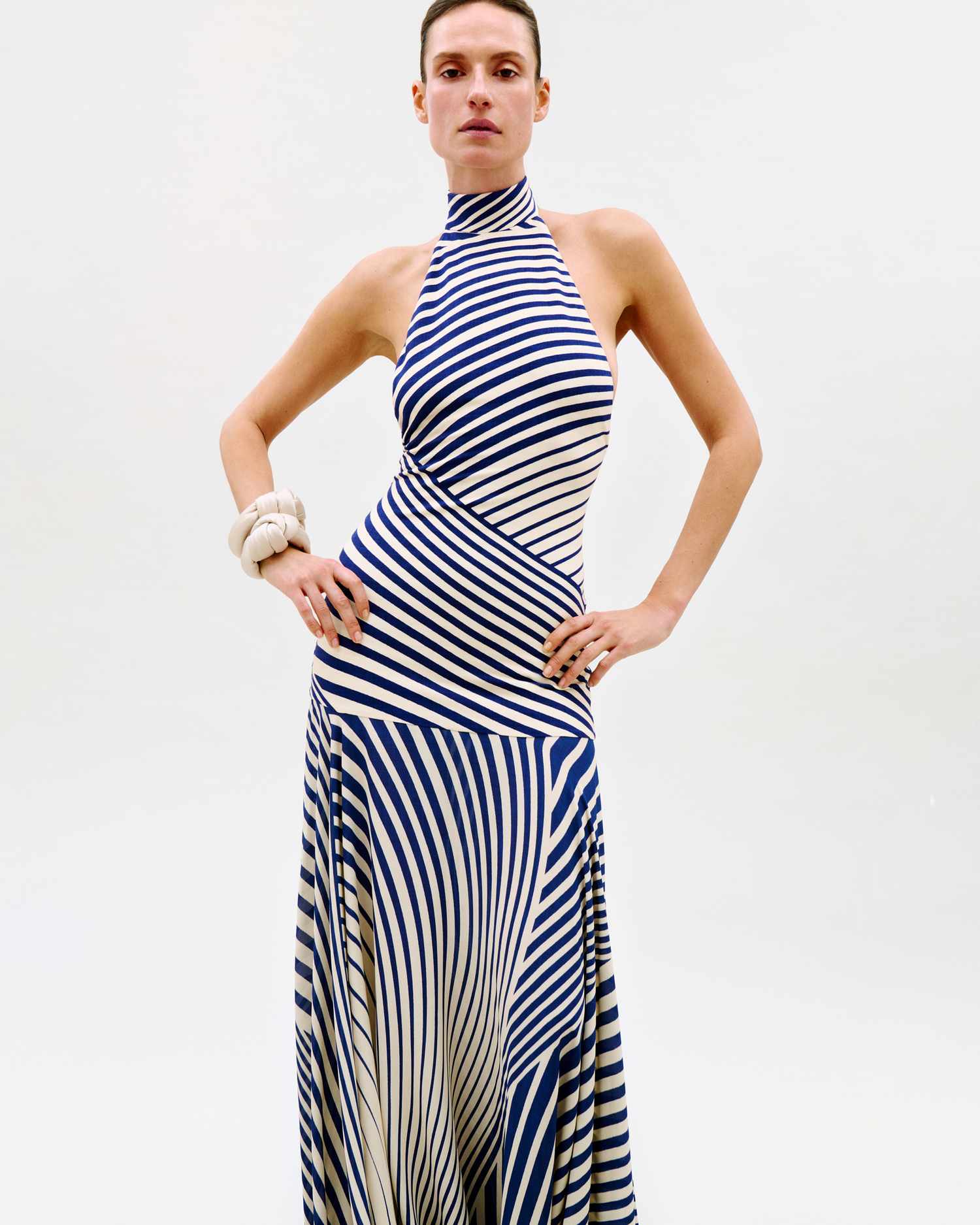 Woman wearing a blue and white striped dress against a plain background