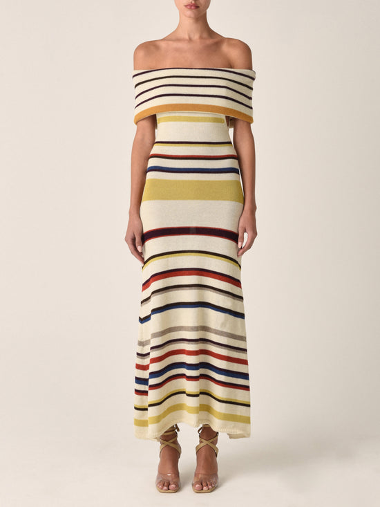 Introducing the Eva Dress Multi Mustard Stripe: a sleeveless, off-the-shoulder marvel crafted from 100% baby alpaca. This form-fitting top flares out slightly at the bottom and features vibrant, multi-colored stripes including yellow, brown, red, and blue.