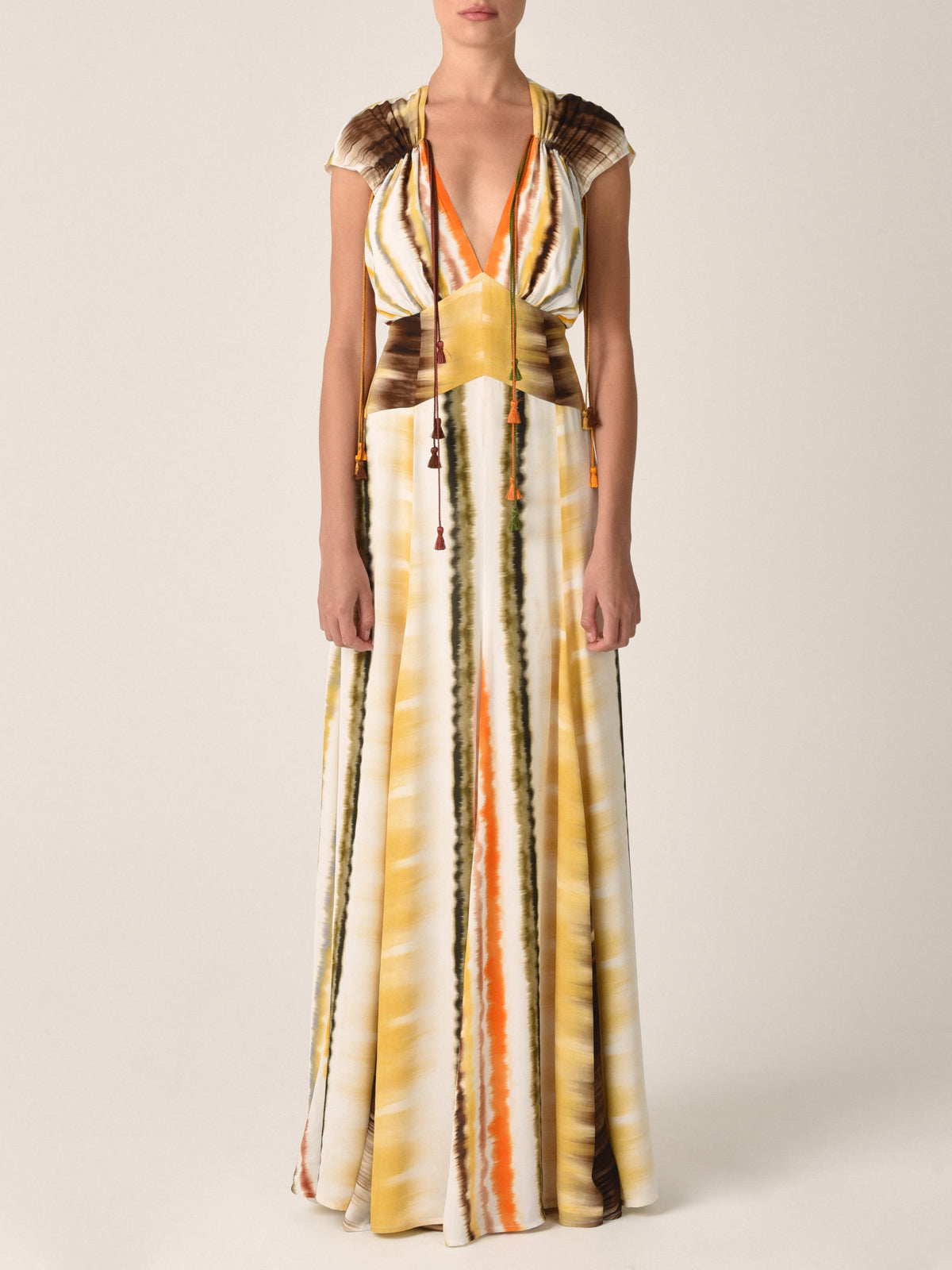 The Marion Dress Multi Hazy Stripe from the Resort 2023 collection features a sleeveless, floor-length design with a multi hazy stripe print in yellow, orange, and brown. It boasts a v-neckline and keyhole opening at the back.