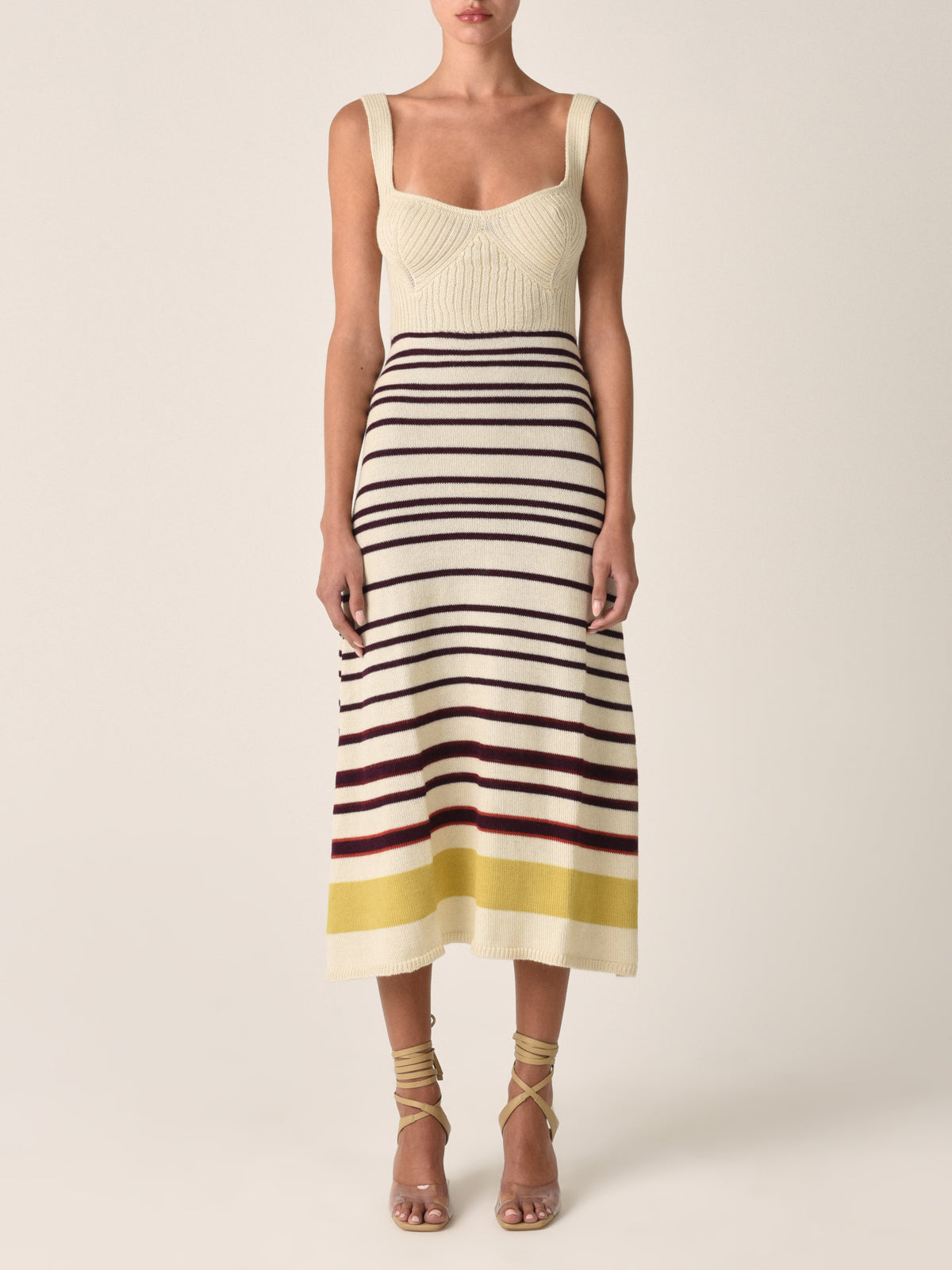 Sleeveless a-line Muriel Dress Multi Mustard Stripe with a beige top and horizontal stripes in black, red, and yellow on the skirt, displayed on a white background.