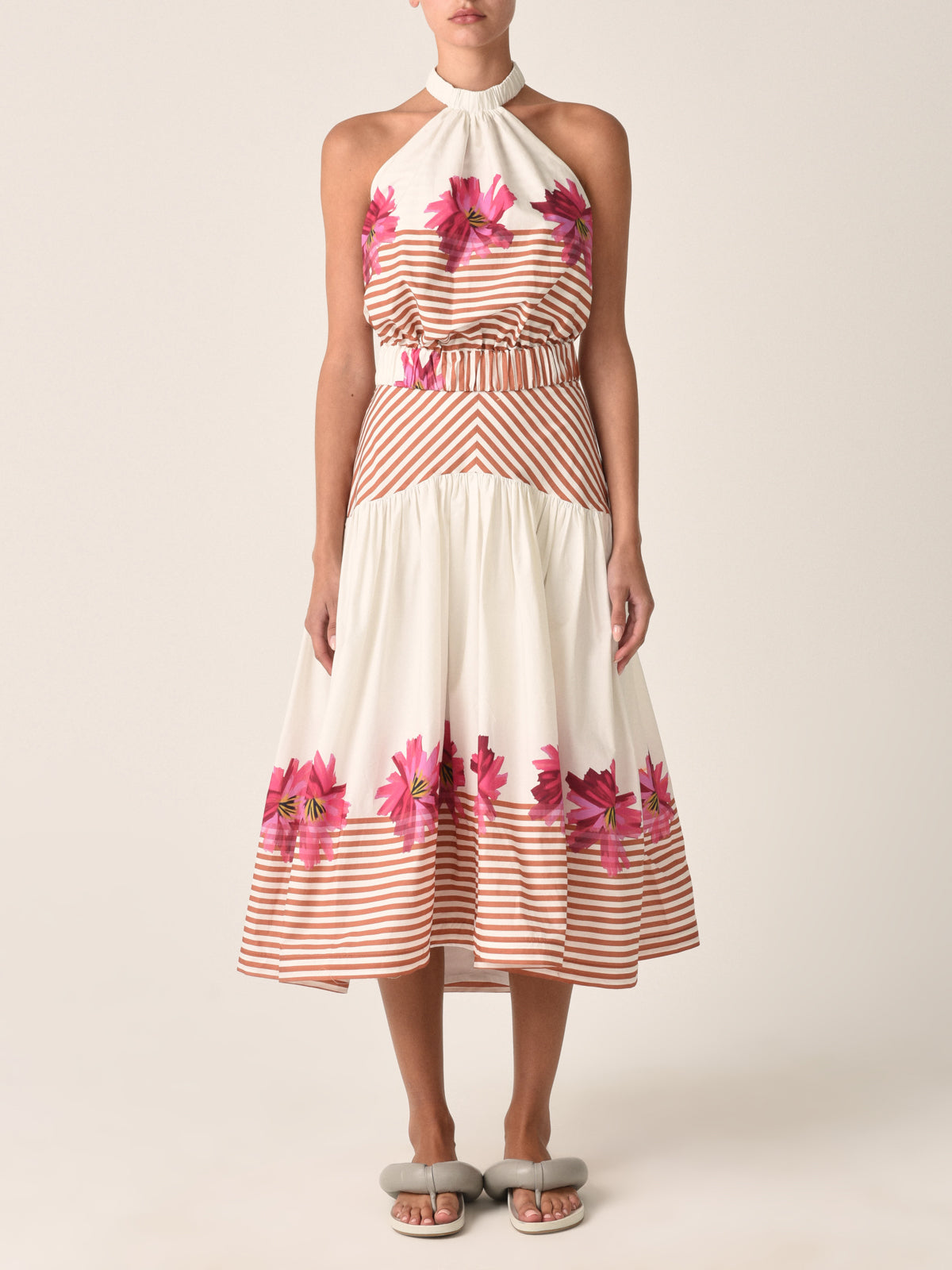 A white midi skirt named "Lilan Skirt Magenta Floral Brushstroke Stripes" with horizontal brown stripes at the top and bottom, featuring a pattern of pink flowers near the hem.