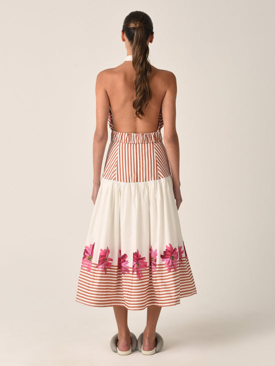 A white midi skirt named "Lilan Skirt Magenta Floral Brushstroke Stripes" with horizontal brown stripes at the top and bottom, featuring a pattern of pink flowers near the hem.