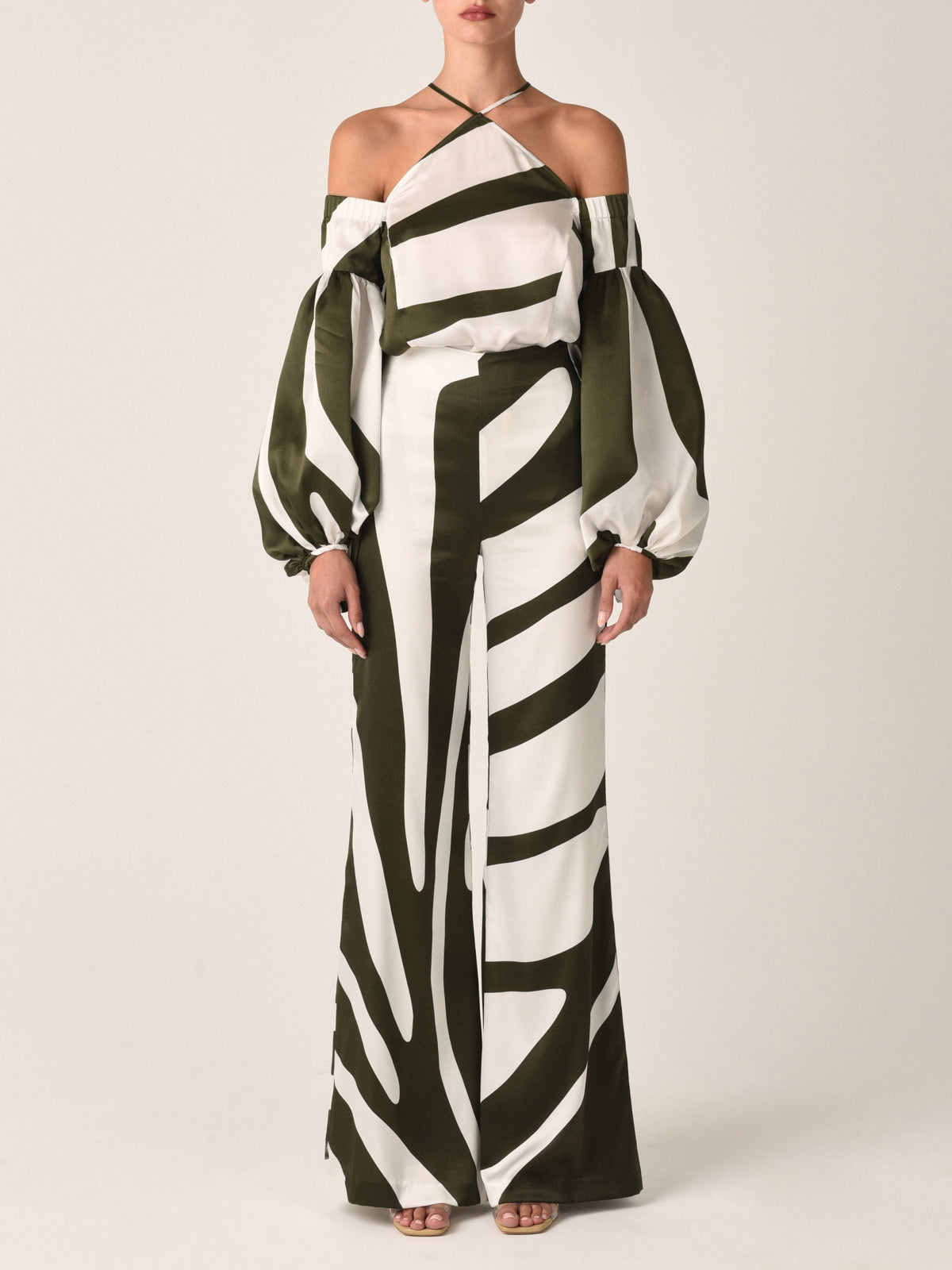 A white and dark green off-the-shoulder blouse with a striped pattern, bishop sleeves, and thin straps, similar in style to the Terry Blouse Green Abstract.