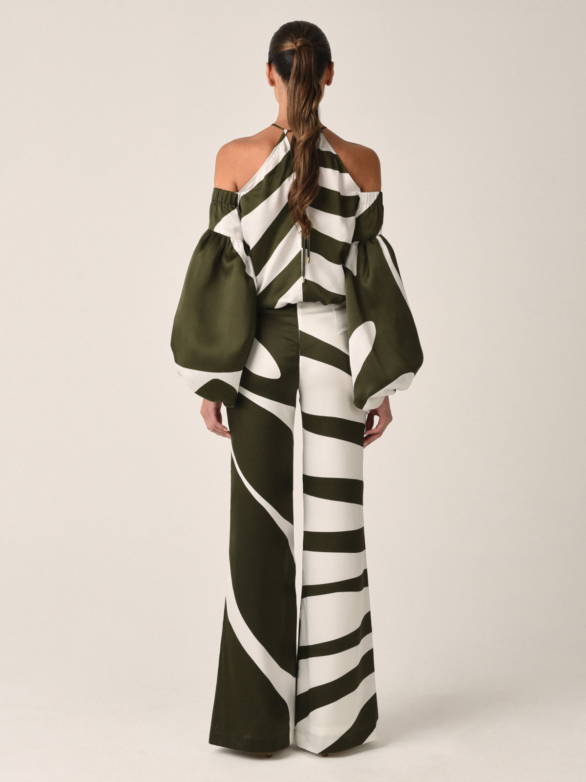 A white and dark green off-the-shoulder blouse with a striped pattern, bishop sleeves, and thin straps, similar in style to the Terry Blouse Green Abstract.