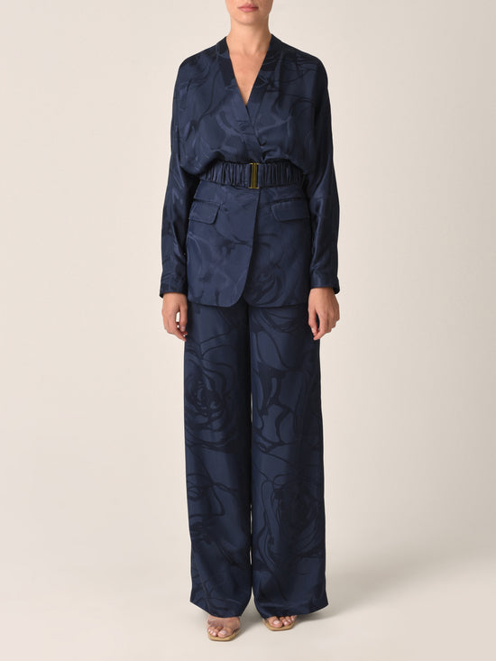 Casey Pant Navy Jacquard, these high-waisted, wide-leg pants featuring a subtle floral pattern in luxurious jacquard fabric and a gathered waistband detail.