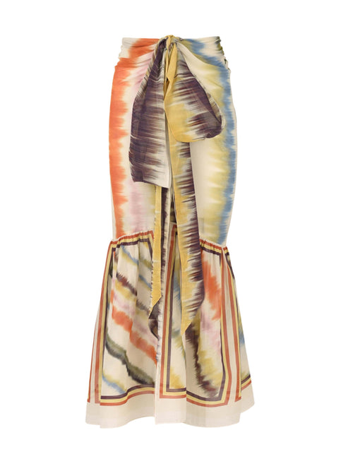 Experience the vibrant Portia Skirt Multi Hazy Stripe, a tie-dye maxi skirt with a wrap pareo design in lightweight cotton voile, showcasing shades of orange, blue, and yellow.