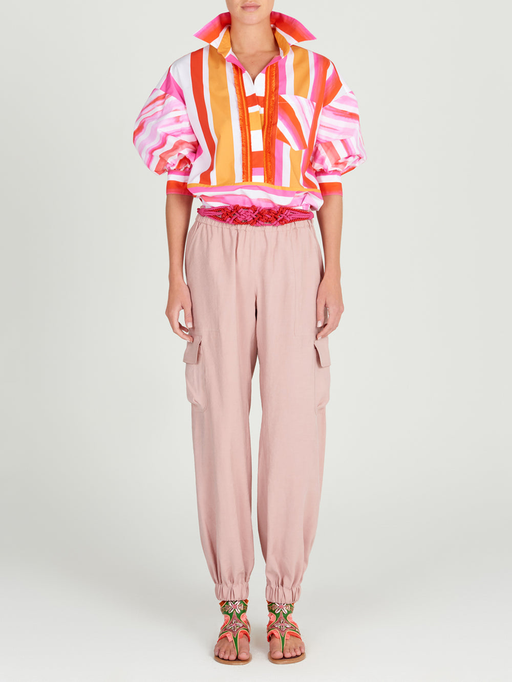 A Manrola Blouse Rouge Orange Stripes with orange and pink watercolor brushstrokes.