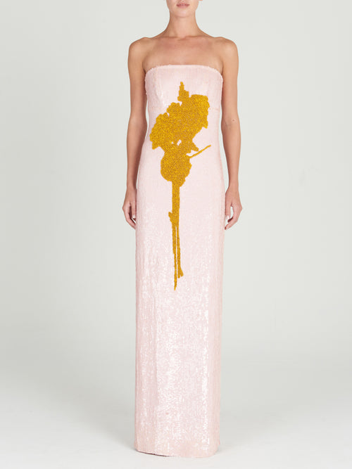 A Margaret Dress Yellow Nude Floral hand-embroidered with a gold flower.