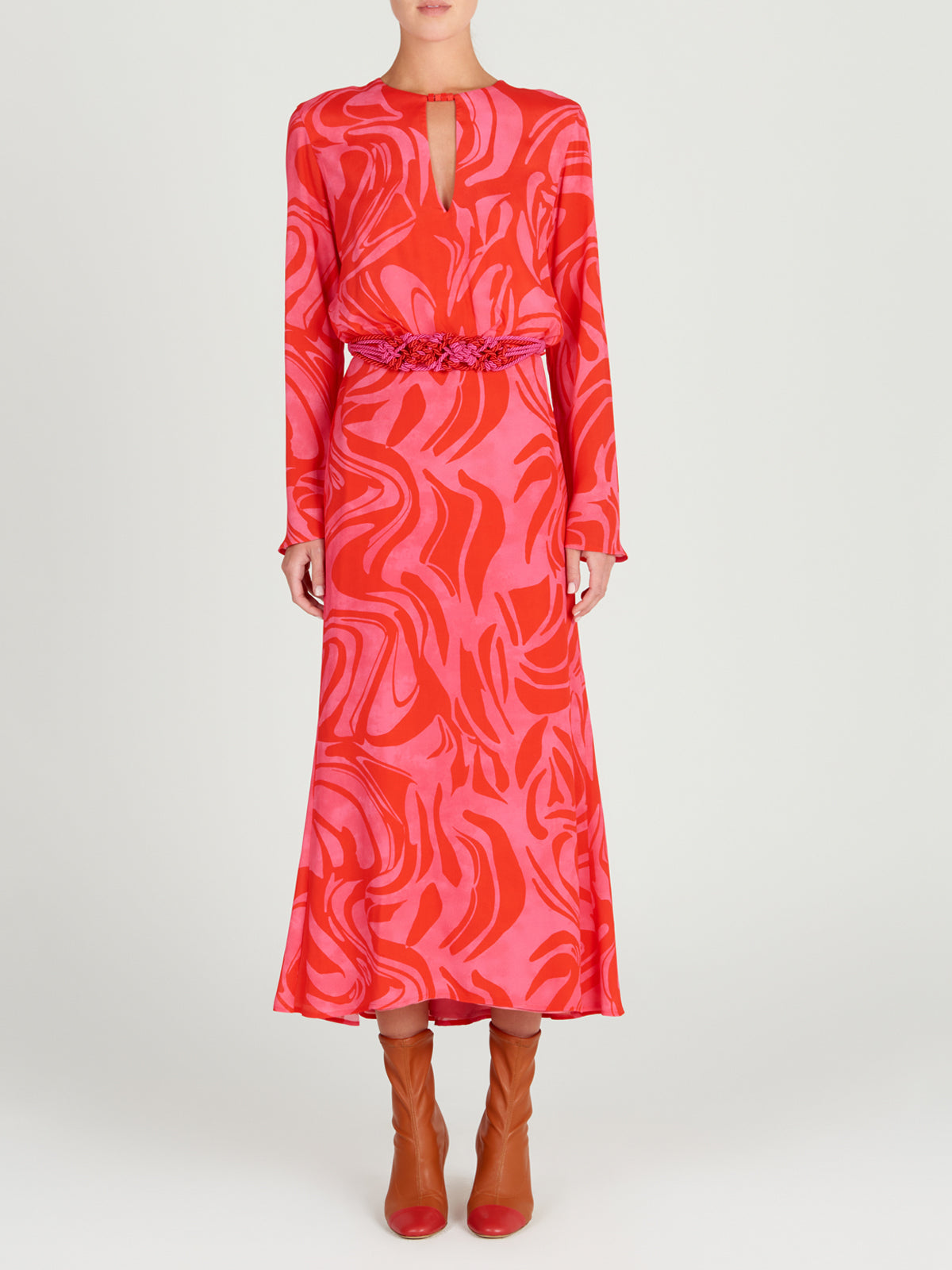 The Pesaro Dress Pink Red Marble is a long-sleeved transitional day-to-night piece, showcasing an abstract swirl pattern with a floral waistband detail.