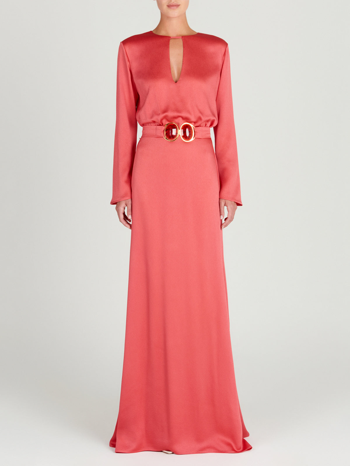 A sleek Ravenna Dress Coral floor-length dress with a belt.