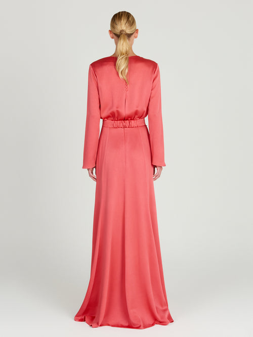 A sleek Ravenna Dress Coral floor-length dress with a belt.