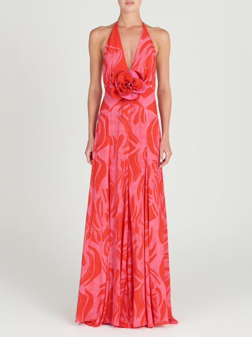 A floor-length Tawny Dress Pink Red Marble with a halt neckline in an abstract floral pattern.