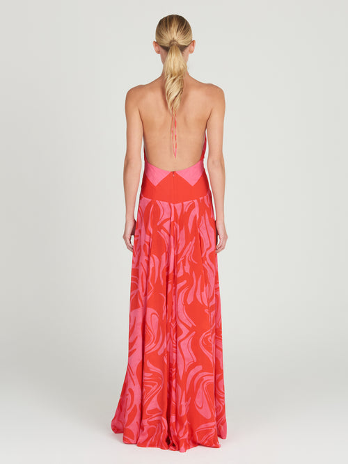 A floor-length Tawny Dress Pink Red Marble with a halt neckline in an abstract floral pattern.