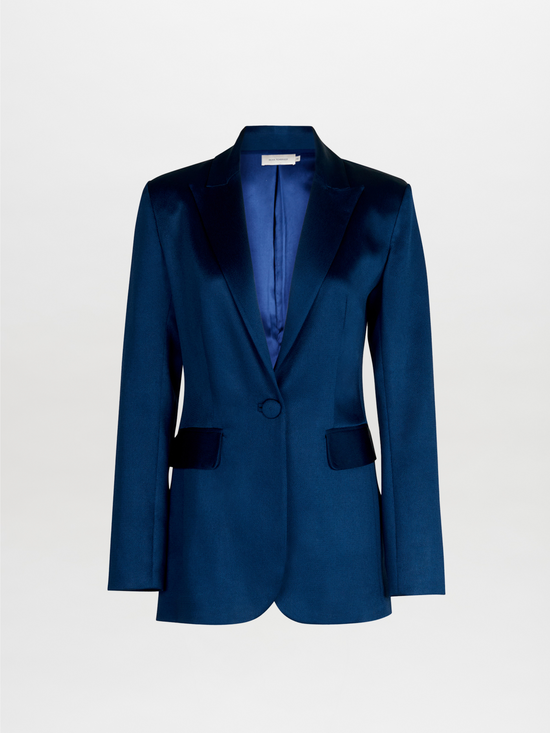 The Rebeca Jacket Navy, a tailored blue velvet blazer featuring a single button and notched lapels, exudes the elegance of a novelty jacket and is presented against a plain background.