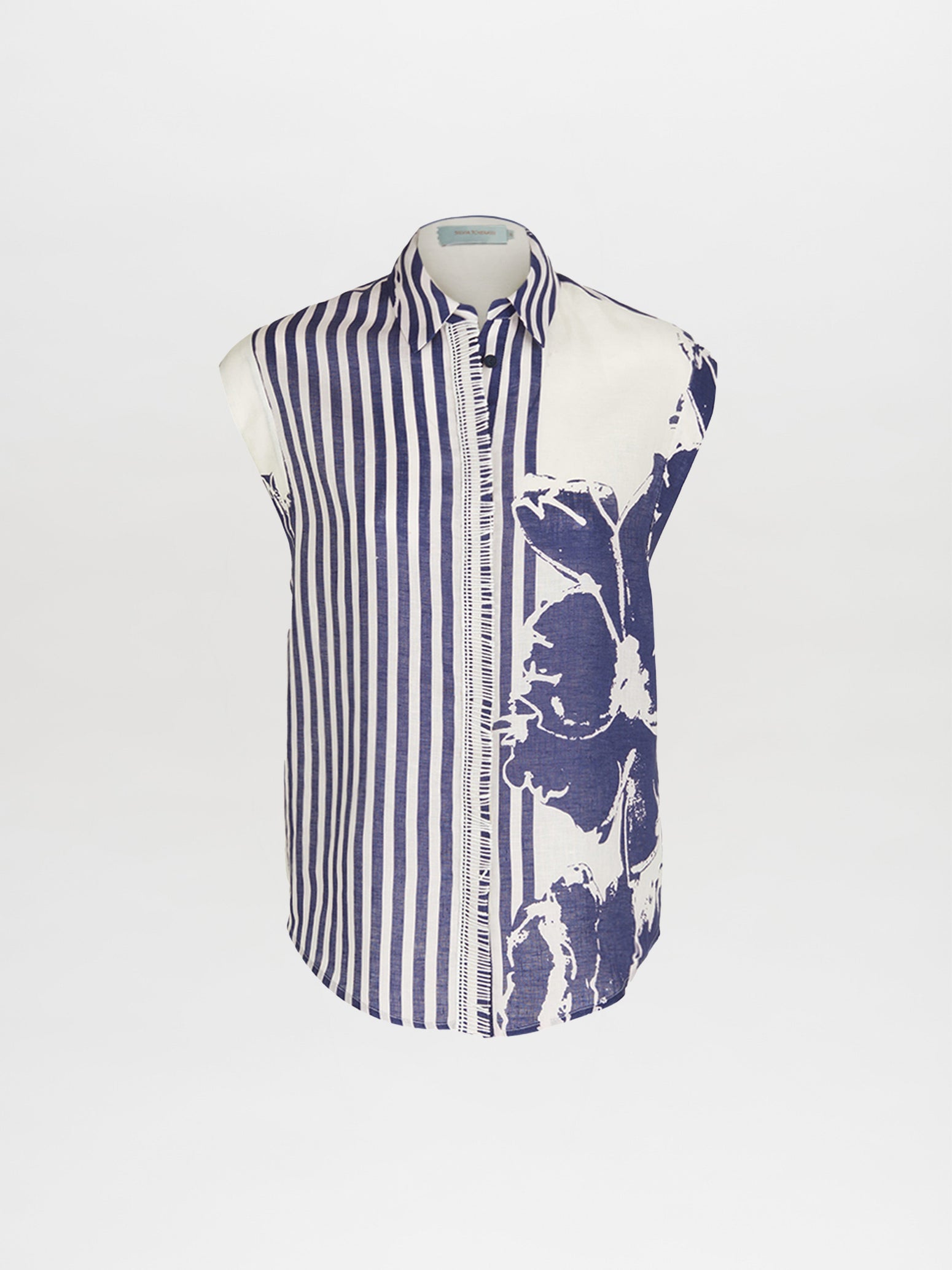 The Rina Blouse Azure Floral Stripes is a high fashion sleeveless shirt featuring vibrant azure floral stripes on the left side and a striking large blue floral pattern on the right side.