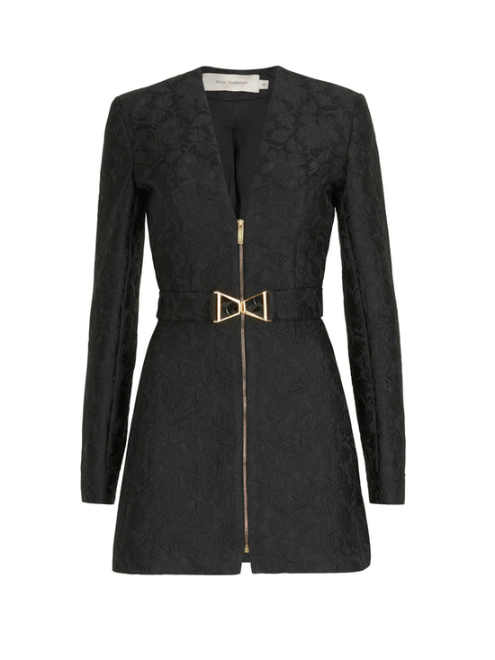 Romana Dress Black: A black long-sleeve mini dress featuring a floral pattern, front zipper, and gold bow belt, crafted from brocade fabric for an elegant touch.