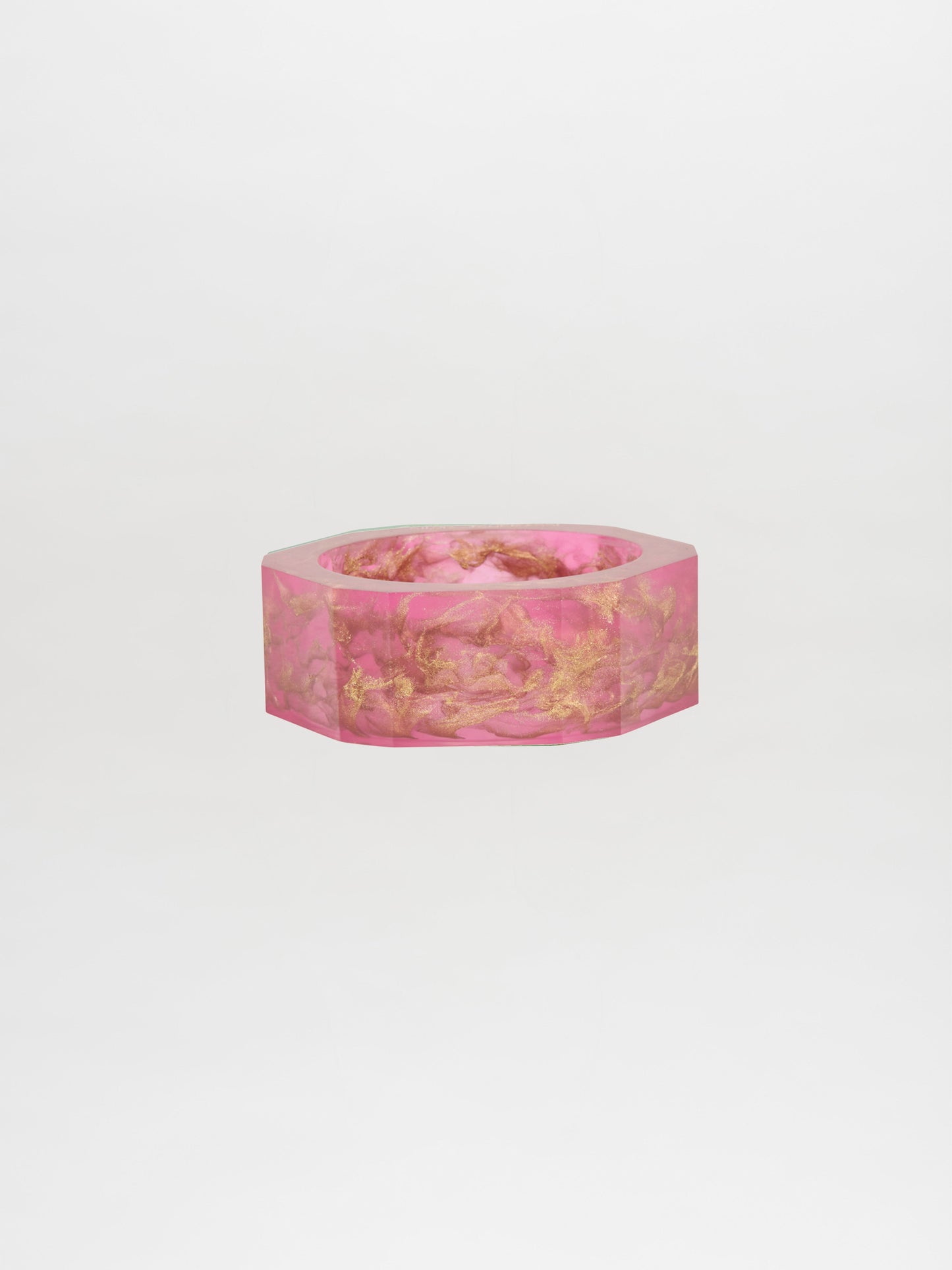 Introducing the Ruth Bangle Fuschia, a hexagonal pink bracelet featuring elegant gold accents, beautifully showcased against a plain white background. Place your order today and savor the excitement as it is custom-made for you, ready to be shipped in just two weeks.