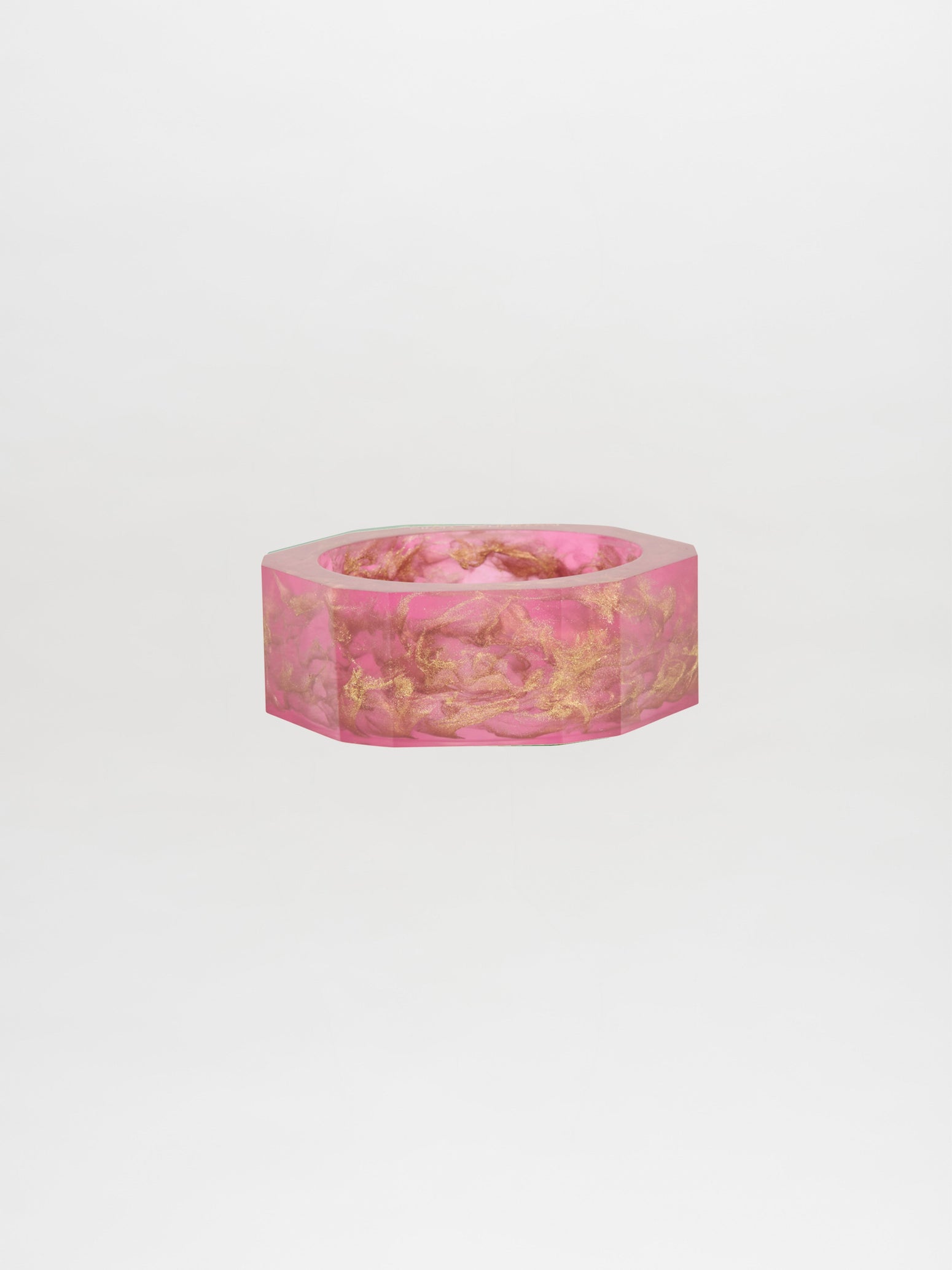 Introducing the Ruth Bangle Fuschia, a hexagonal pink bracelet featuring elegant gold accents, beautifully showcased against a plain white background. Place your order today and savor the excitement as it is custom-made for you, ready to be shipped in just two weeks.