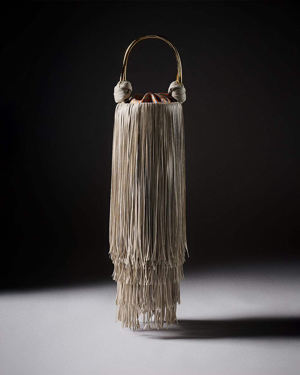 Decorative vase with fringes on a dark background