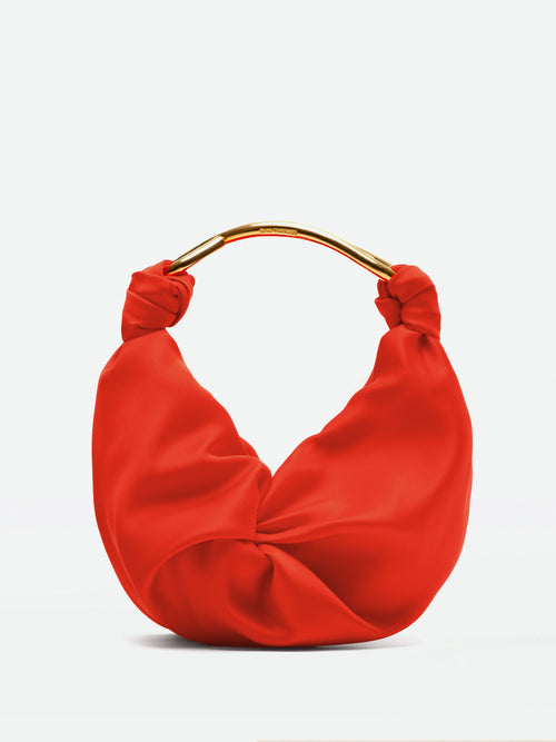 The Sofia Bag Small is a red, crescent-shaped handbag crafted from luxurious doppio raso with a gold handle, showcased against a plain background.