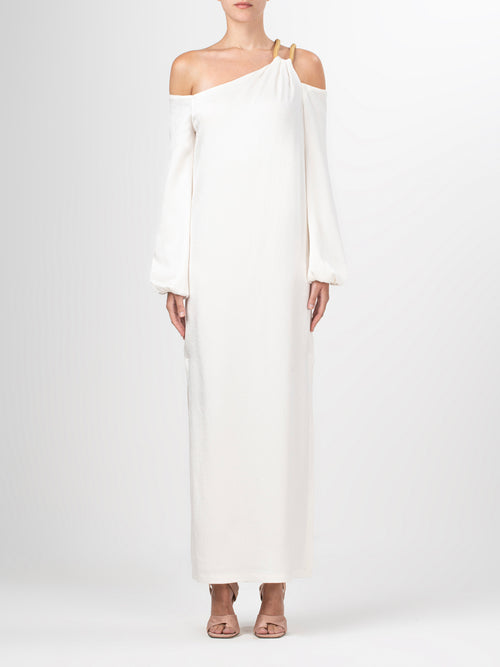 A Ada Dress White with a metallic gold shoulder detail.