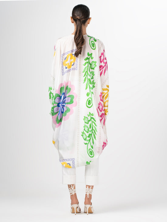 A white poncho with Adaya Tunic Multicolor Floral Print designs.