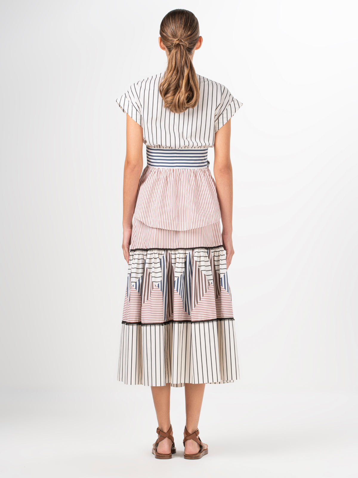 A white and blue striped Elia blouse with a bow, made of cotton fabric.