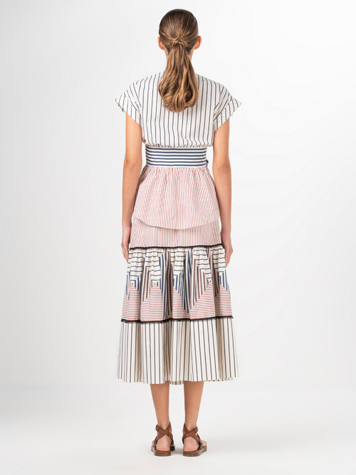 A white and blue striped Elia blouse with a bow, made of cotton fabric.