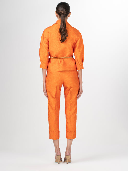 A women's Gianna Jacket Orange Petal with a belt, featuring a relaxed fit.