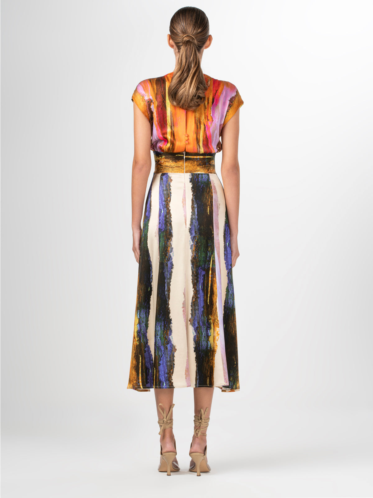 A Ivanova Dress Orange Orchid Abstract Stripes displayed on a mannequin with a V neckline.