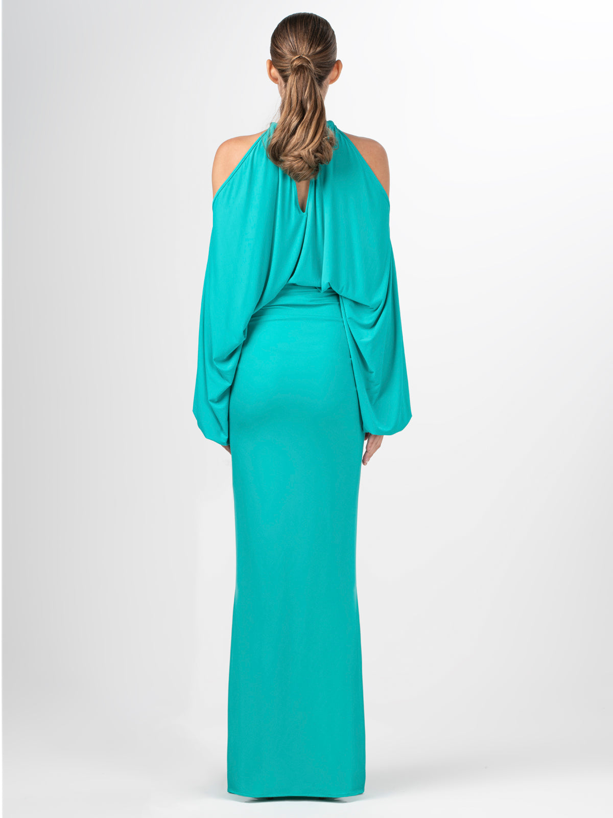 A Janina Blouse Aqua with a metallic jewelry detail around the neck.