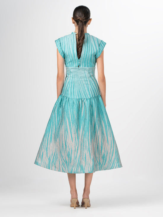 The Conza Dress Aqua Abstract Ripple is a sleeveless midi dress in teal and beige, made from multicolor textured taffeta with a fitted silhouette, flared skirt, and subtle vertical stripe pattern.