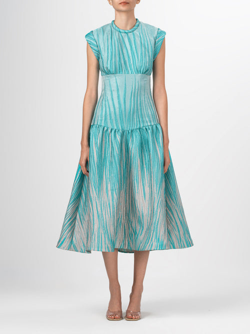 The Conza Dress Aqua Abstract Ripple is a sleeveless midi dress in teal and beige, made from multicolor textured taffeta with a fitted silhouette, flared skirt, and subtle vertical stripe pattern.