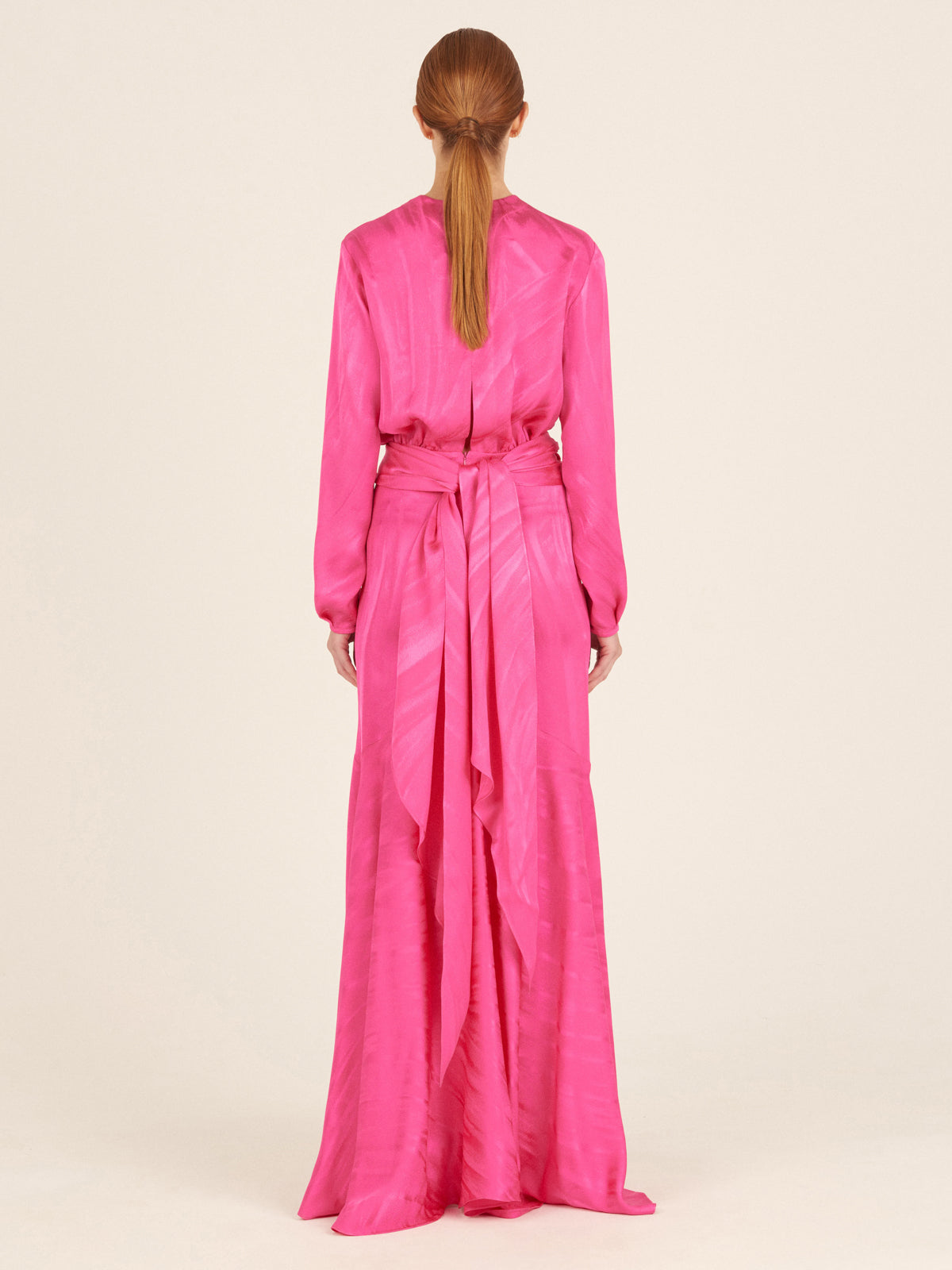 A Albarella Dress Fuchsia with a plunging neckline and a ruffled hem.