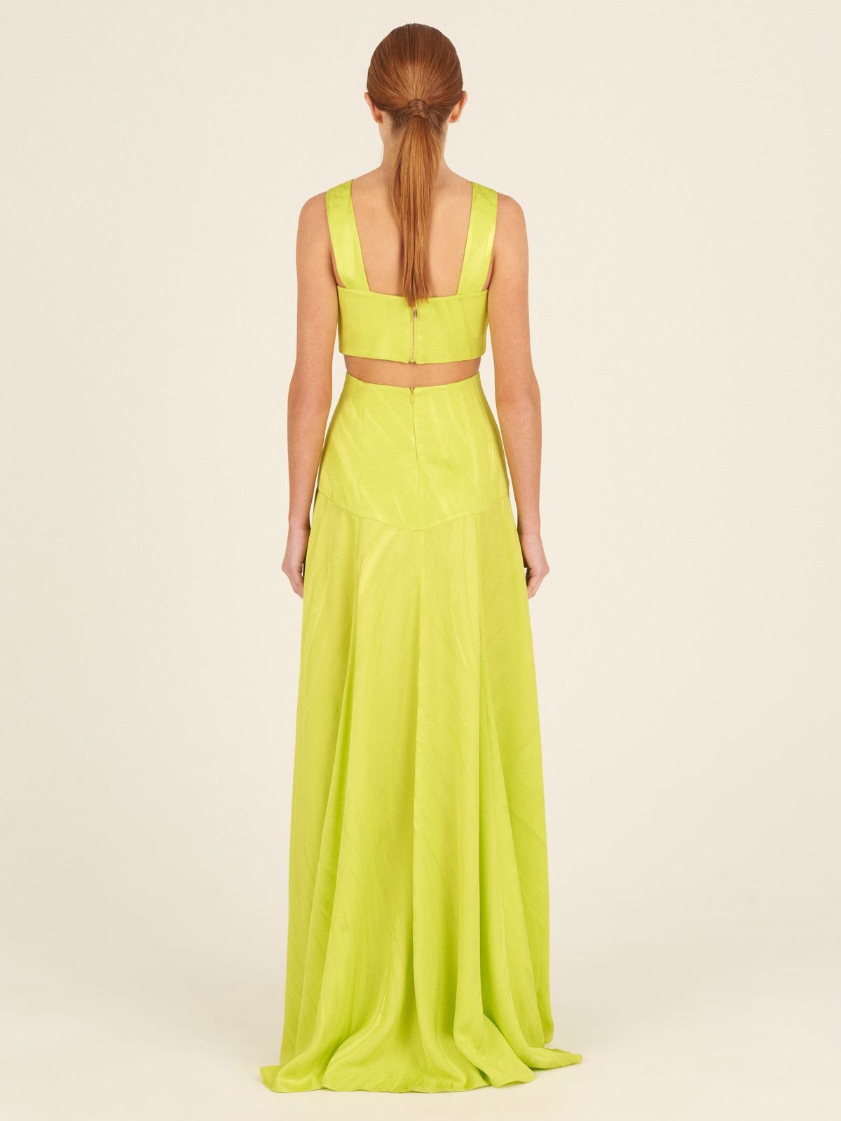 A person wearing the Febe Skirt Verde Lime, which features a cut-out design and an avant-garde, elegantly flowing skirt, making it a statement piece.