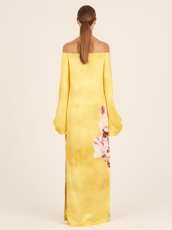 The Lexi Tunic, featuring a floral pattern with canary pink flowers, showcases an off-the-shoulder design and large, gathered sleeve details in yellow.