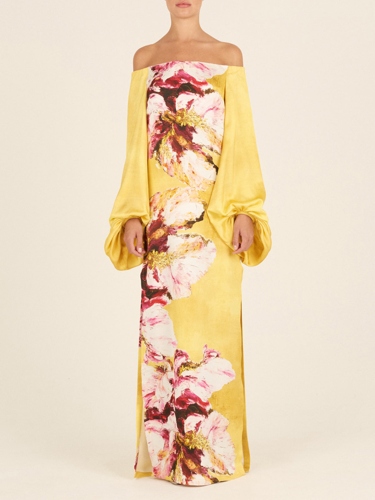 The Lexi Tunic, featuring a floral pattern with canary pink flowers, showcases an off-the-shoulder design and large, gathered sleeve details in yellow.